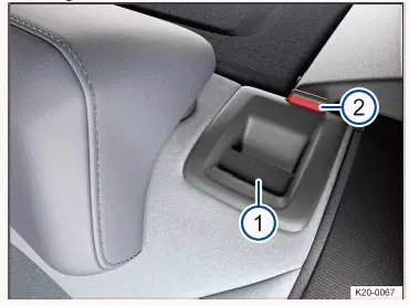 Fig. 1 In the rear seat backrest: release button.